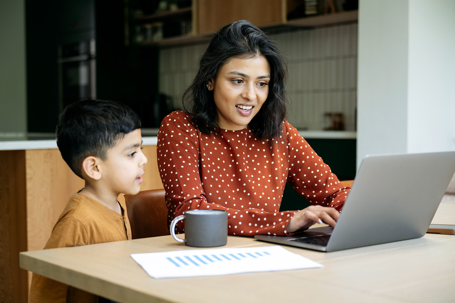 Mother and son looking a laptop in the kitchen
